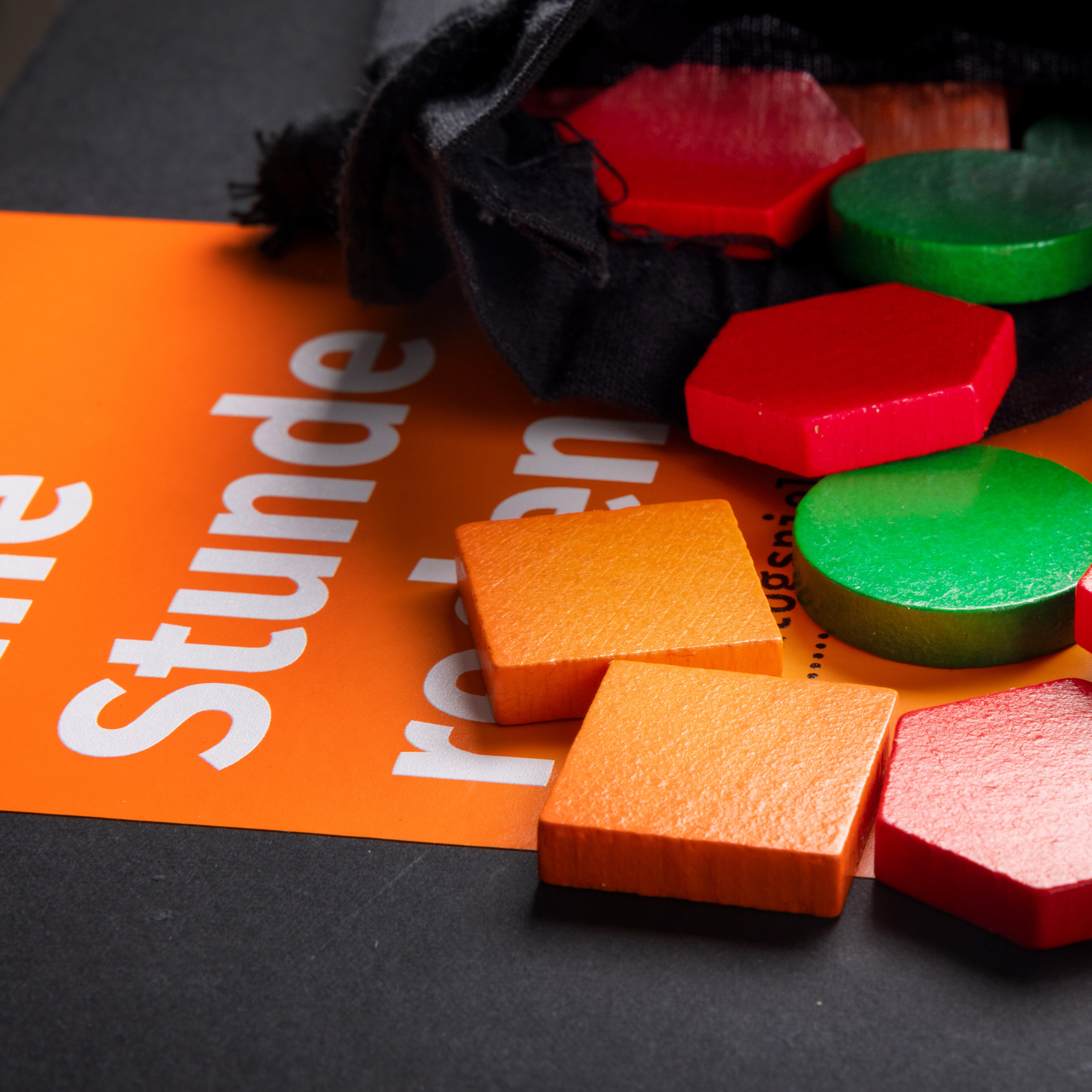 Zu sehen sind bunte Spielsteine auf dem Spielkarton.