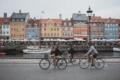 Drei Fahrradfahrer fahren am Nyhavn in Kopenhagen entlang